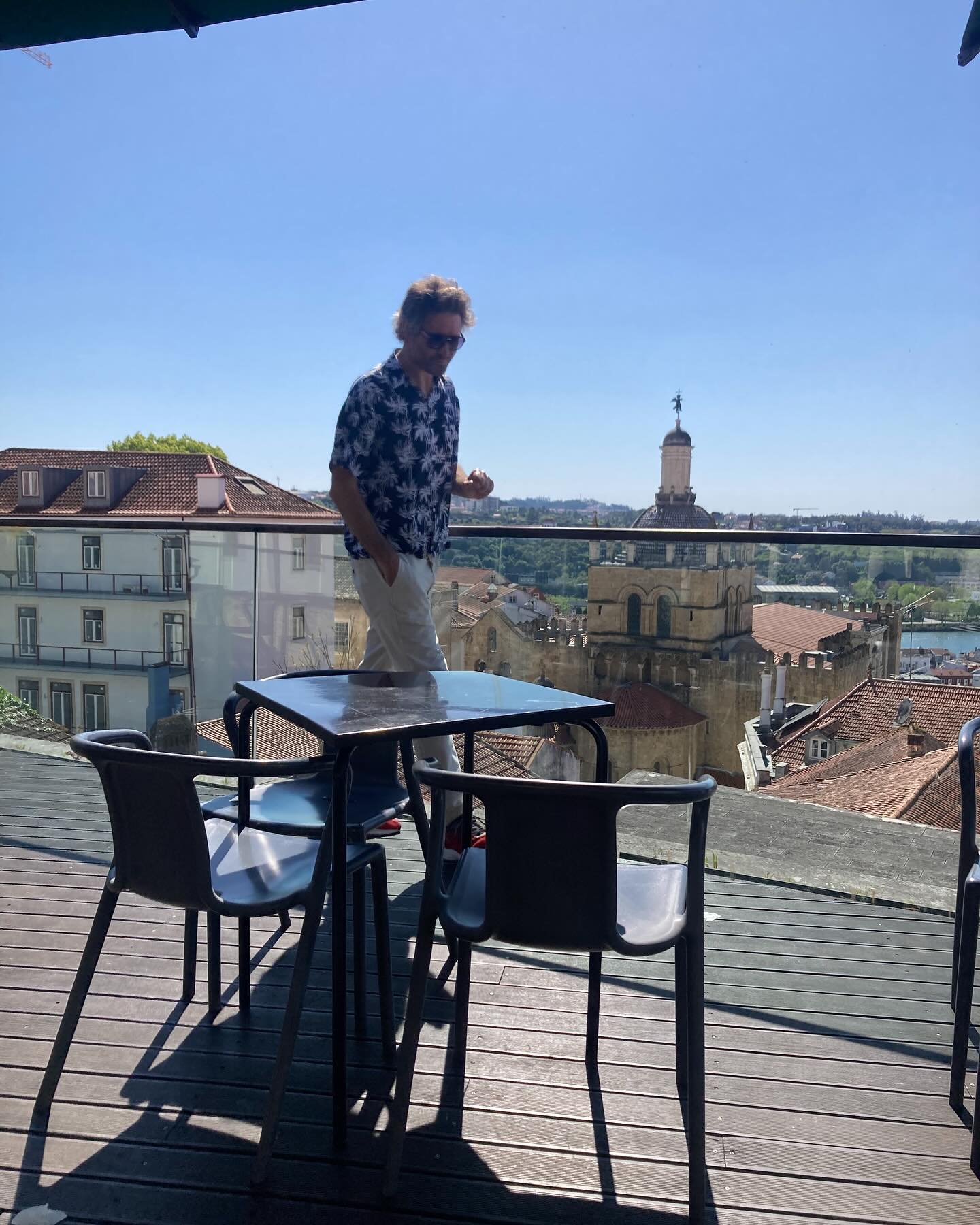 Nigel on a rooftop terrace overlooking the tiled rooftops and old cathedral of Coimbra, Portugal.